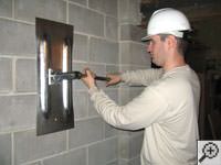 Attempting to straighten a bowed foundation wall by straightening a wall anchor system in a Mableton home.
