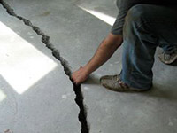 a severely damaged cracked concrete slab floor in Carrollton