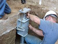 Foundation repair contractors installing the foundation bracket in Roswell.