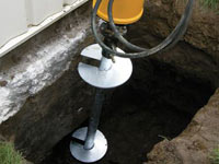 Installing a helical pier system in the earth around a foundation in Athens