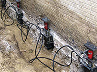 Using foundation push piers to lift a foundation during a repair in Gainesville.