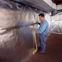 Installation of a radiant heat and vapor barrier on a basement wall in Canton